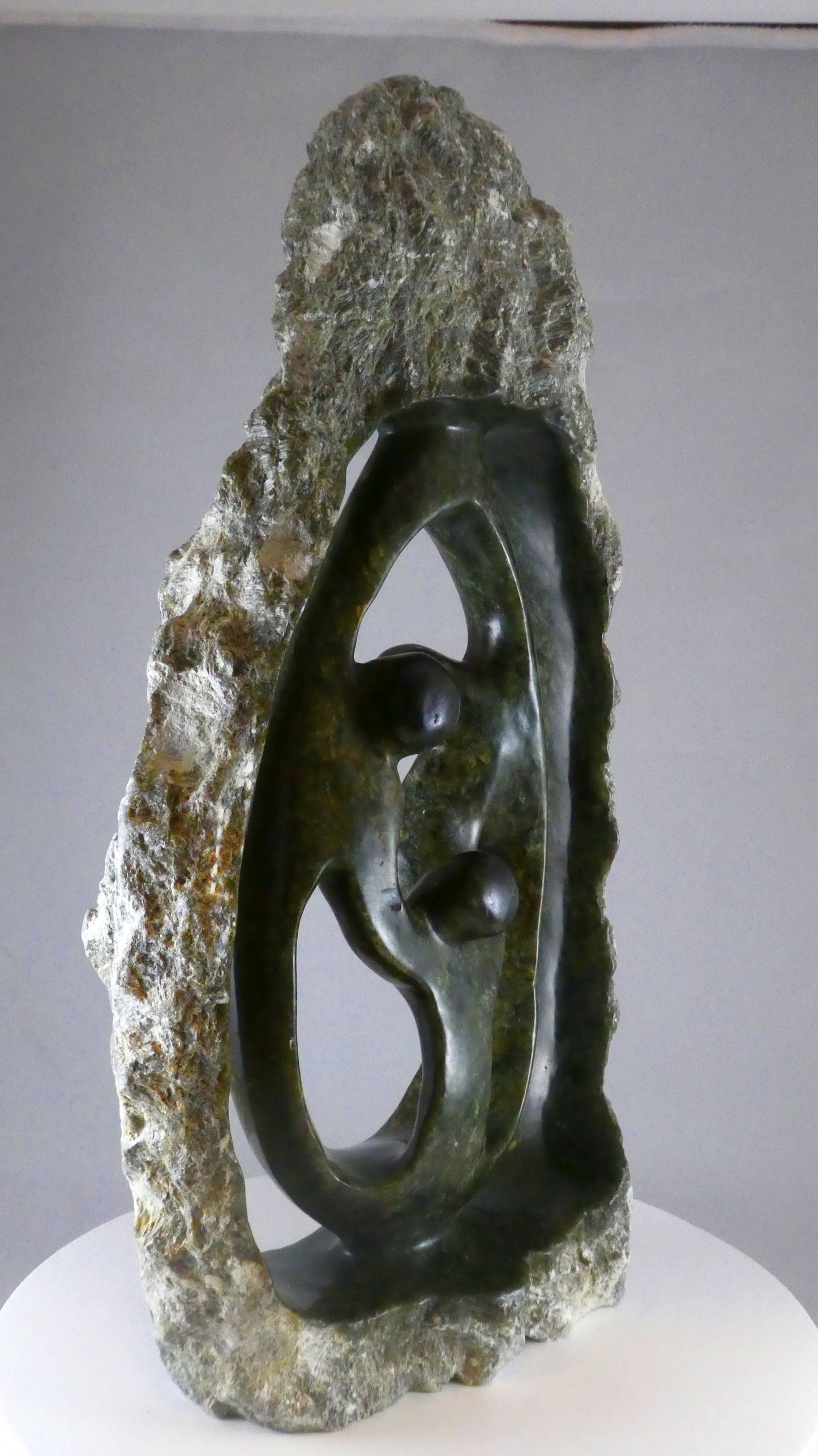 Stenen beeld, 3 personen, 44 cm hoog, buitenzijde ruw, binnenzijde glad afgewerkt