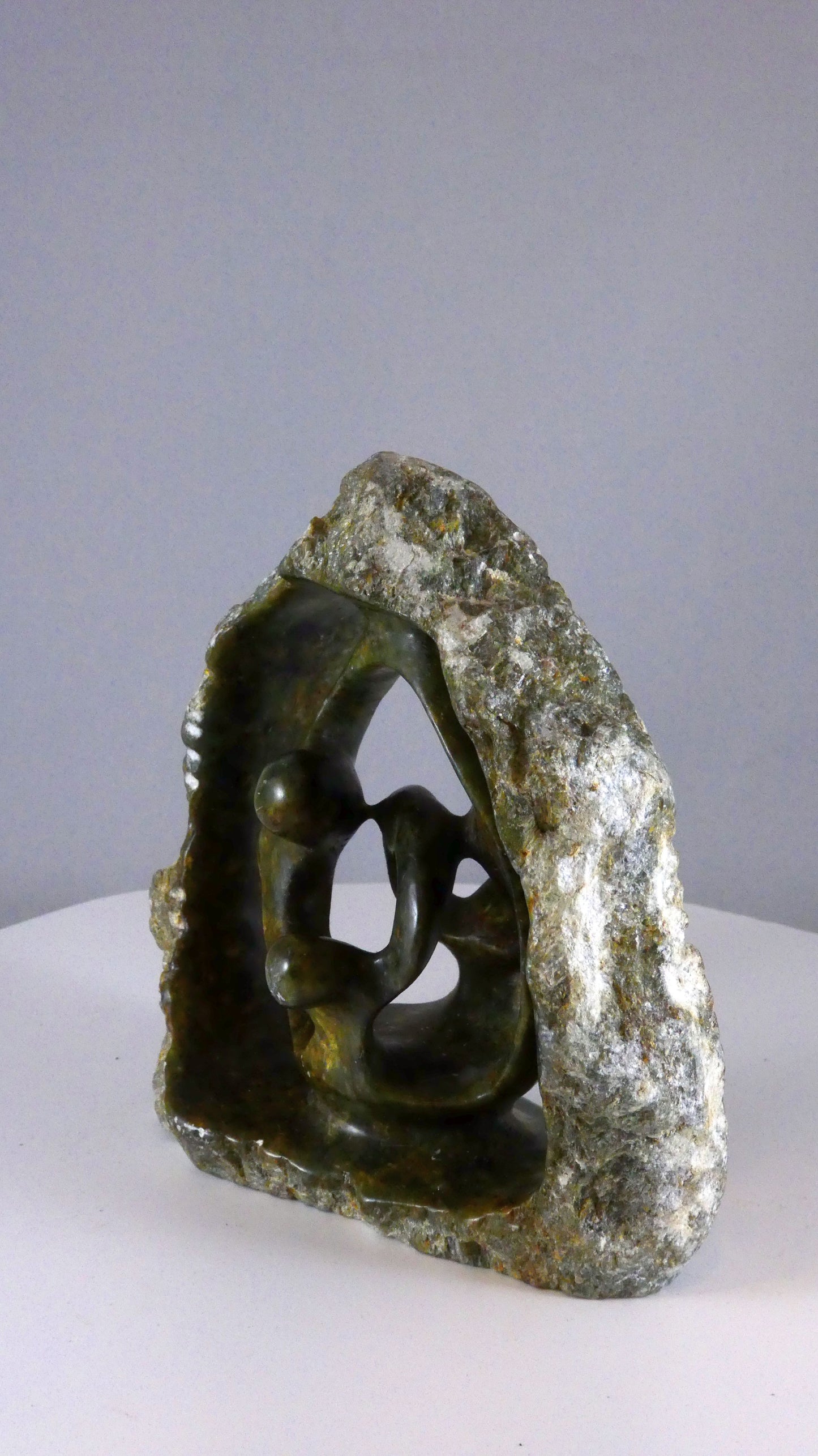 Stenen beeld, 4 personen, 14 cm hoog, buitenzijde ruw, binnenzijde glad afgewerkt