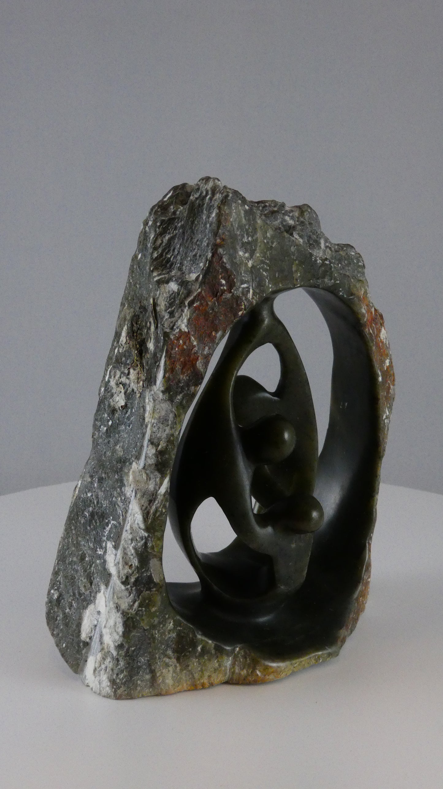 Stenen beeld, 3 personen, 16 cm hoog, buitenzijde ruw, binnenzijde glad afgewerkt