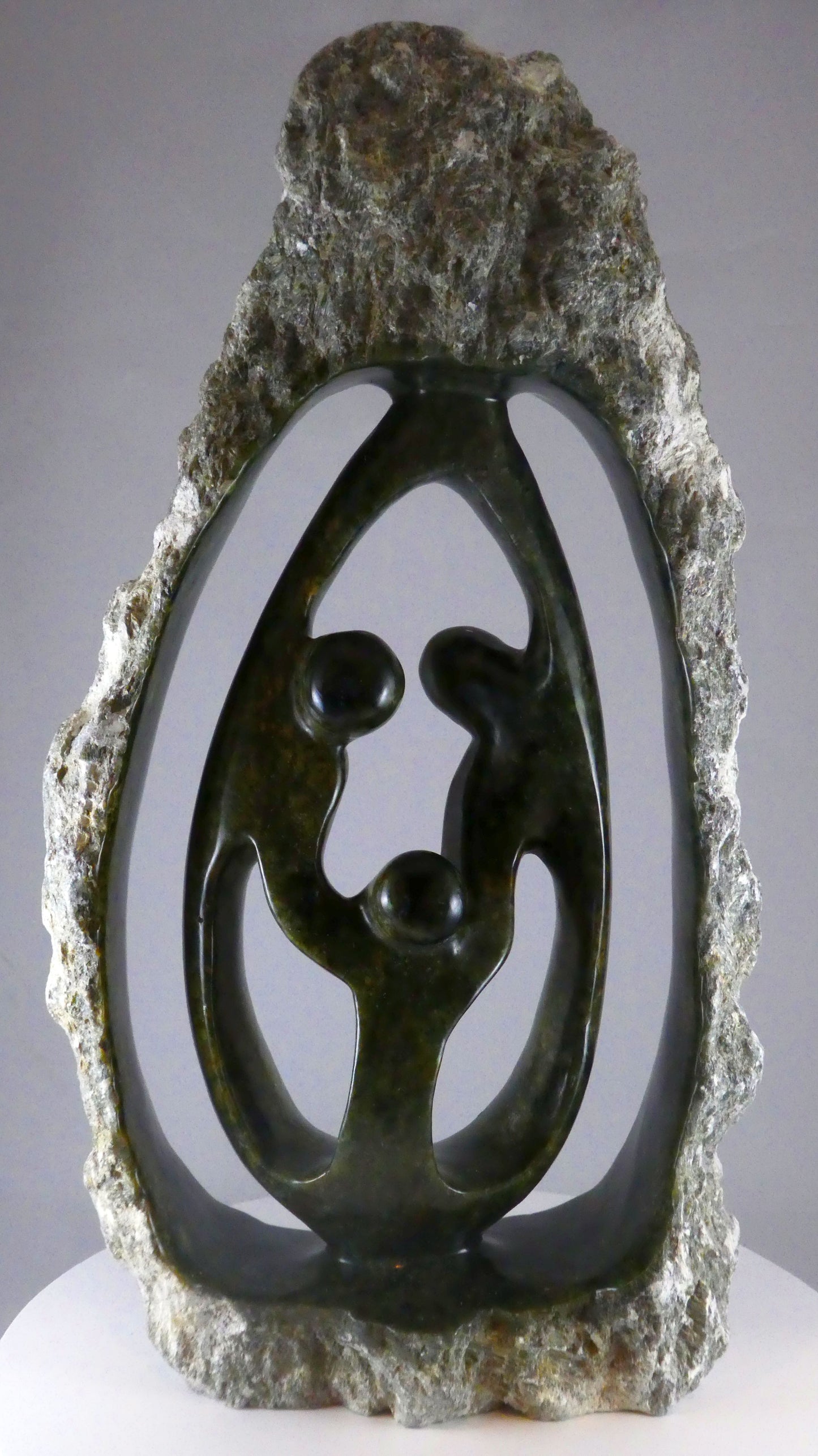 Stenen beeld, 3 personen, 44 cm hoog, buitenzijde ruw, binnenzijde glad afgewerkt