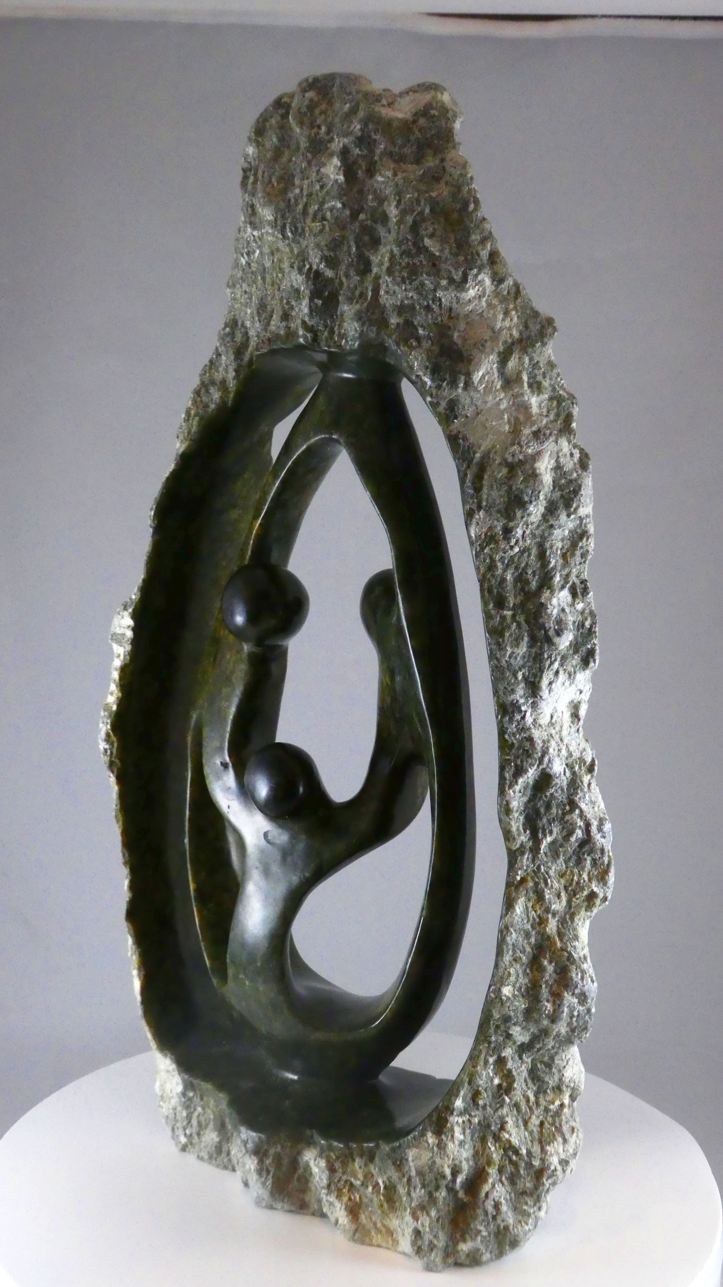 Stenen beeld, 3 personen, 44 cm hoog, buitenzijde ruw, binnenzijde glad afgewerkt