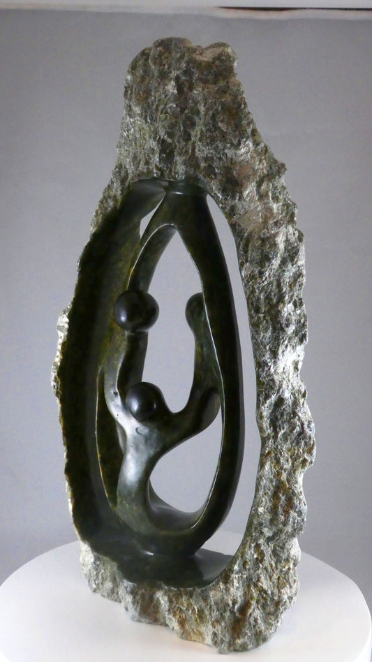 Stenen beeld, 3 personen, 44 cm hoog, buitenzijde ruw, binnenzijde glad afgewerkt