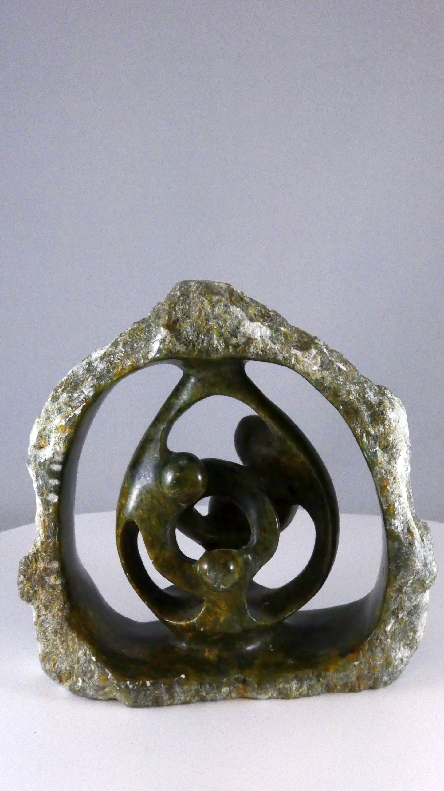 Stenen beeld, 4 personen, 14 cm hoog, buitenzijde ruw, binnenzijde glad afgewerkt