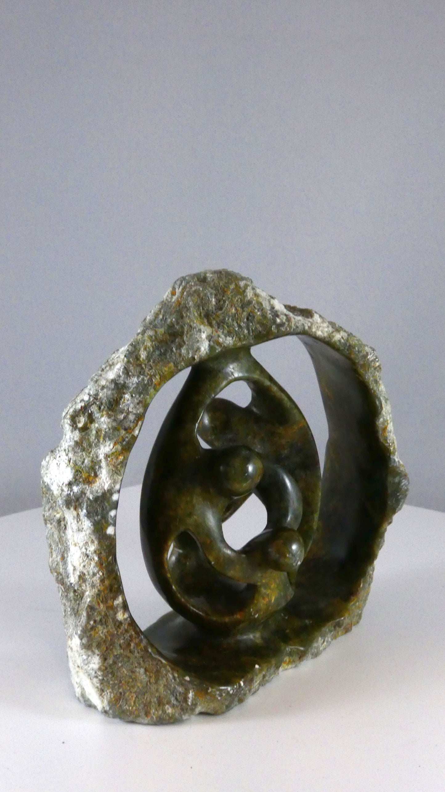 Stenen beeld, 4 personen, 14 cm hoog, buitenzijde ruw, binnenzijde glad afgewerkt