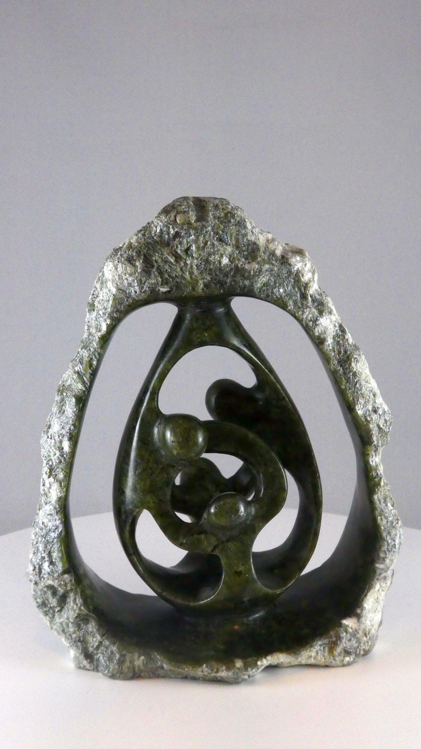 Stenen beeld, 4 personen, 19 cm hoog, buitenzijde ruw, binnenzijde glad afgewerkt