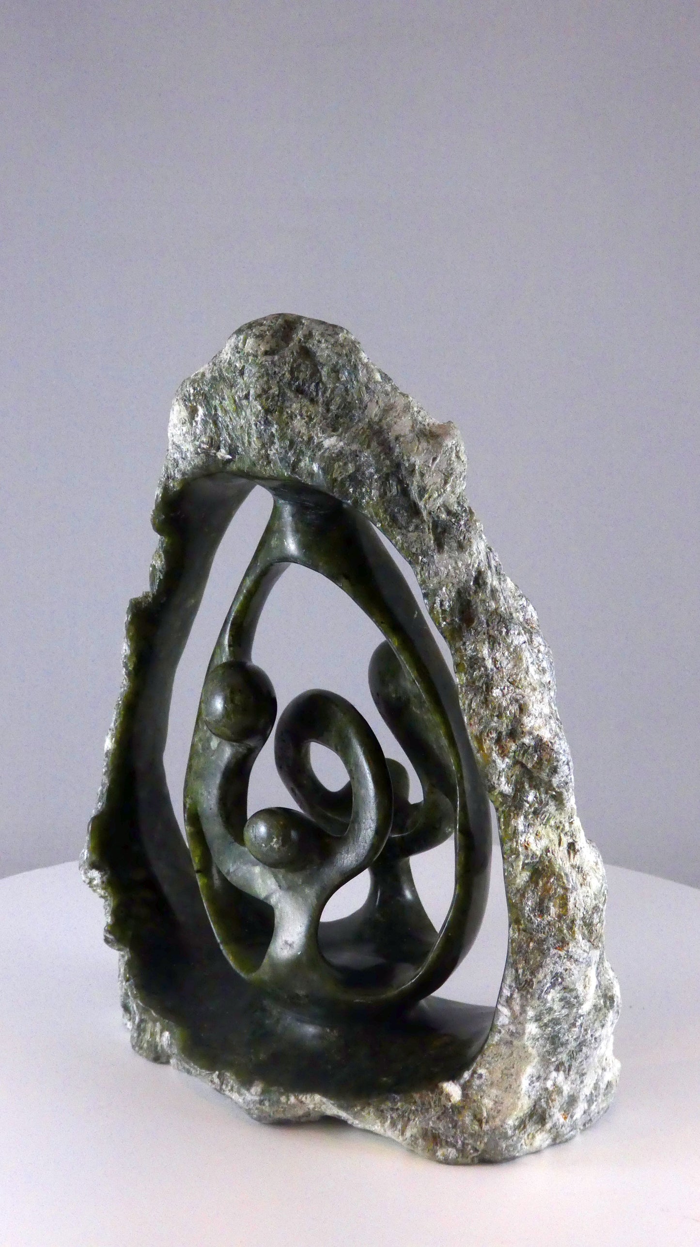 Stenen beeld, 4 personen, 19 cm hoog, buitenzijde ruw, binnenzijde glad afgewerkt