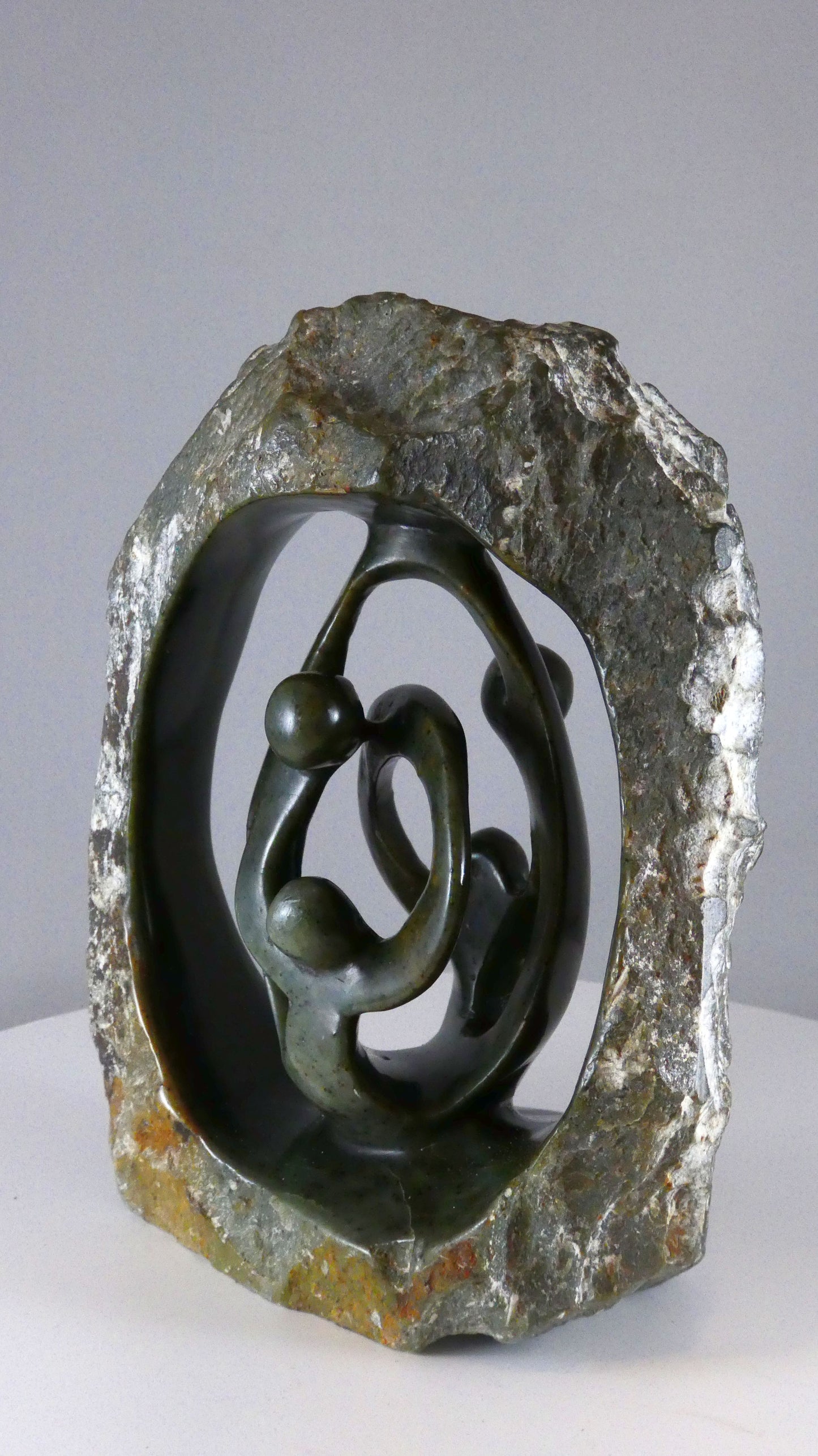 Stenen beeld, 4 personen, 19 cm hoog, buitenzijde ruw, binnenzijde glad afgewerkt