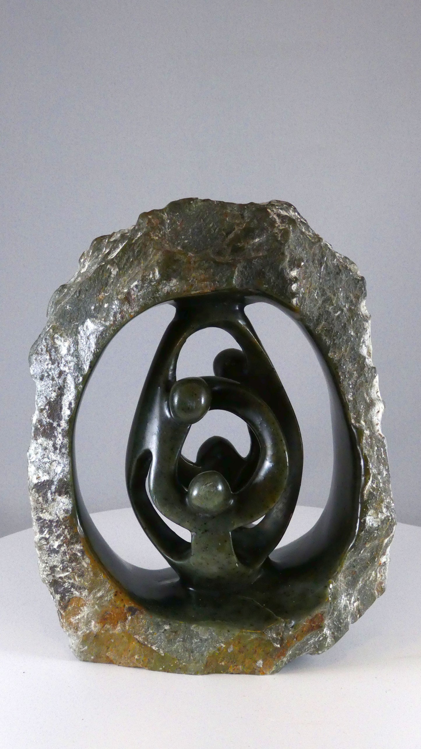 Stenen beeld, 4 personen, 19 cm hoog, buitenzijde ruw, binnenzijde glad afgewerkt