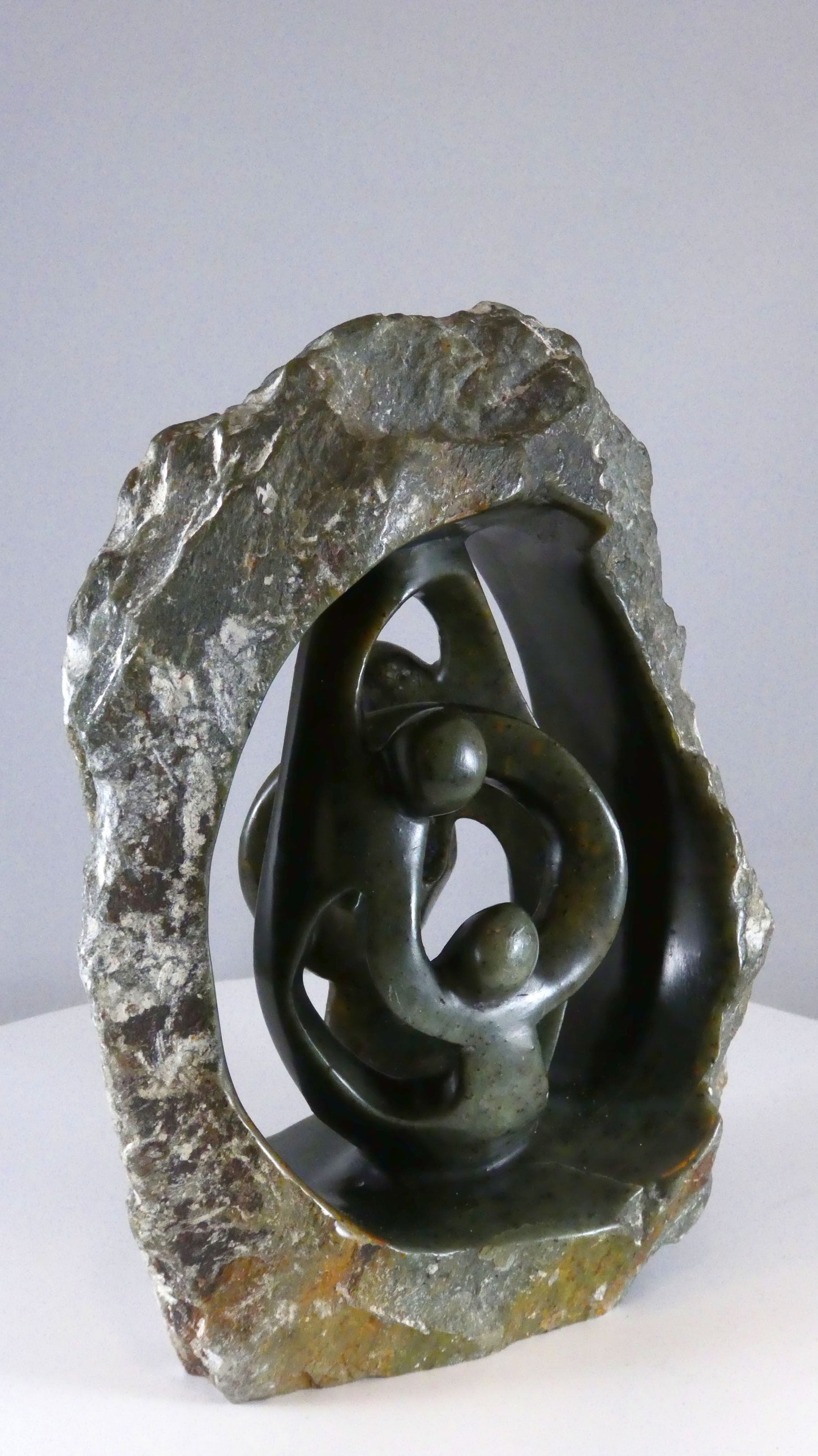 Stenen beeld, 4 personen, 19 cm hoog, buitenzijde ruw, binnenzijde glad afgewerkt