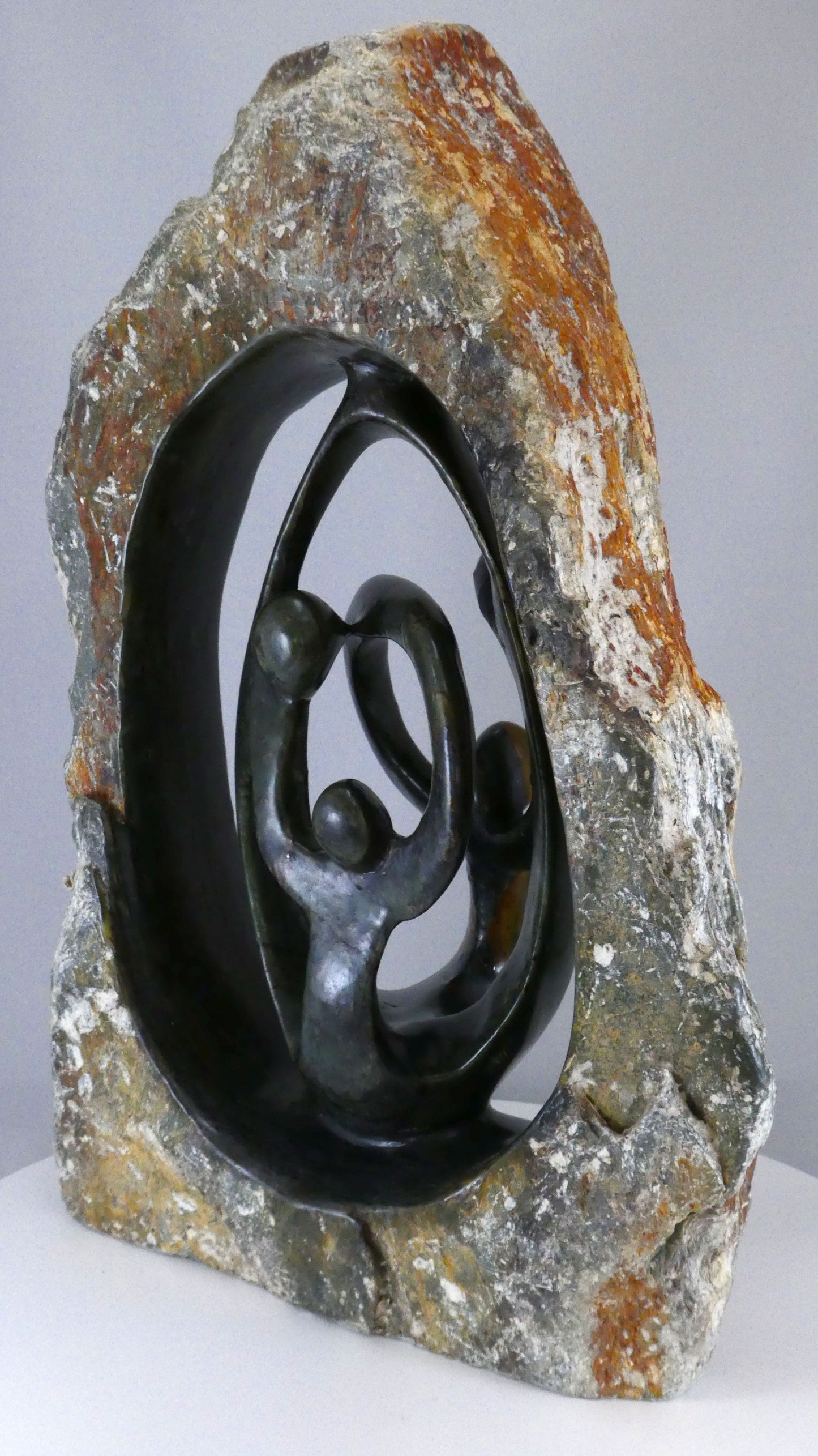 Stenen beeld, 4 personen, 35 cm hoog, buitenzijde ruw, binnenzijde glad afgewerkt