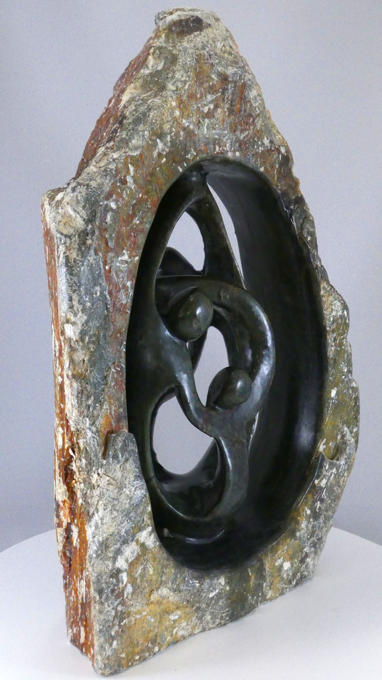 Stenen beeld, 4 personen, 35 cm hoog, buitenzijde ruw, binnenzijde glad afgewerkt