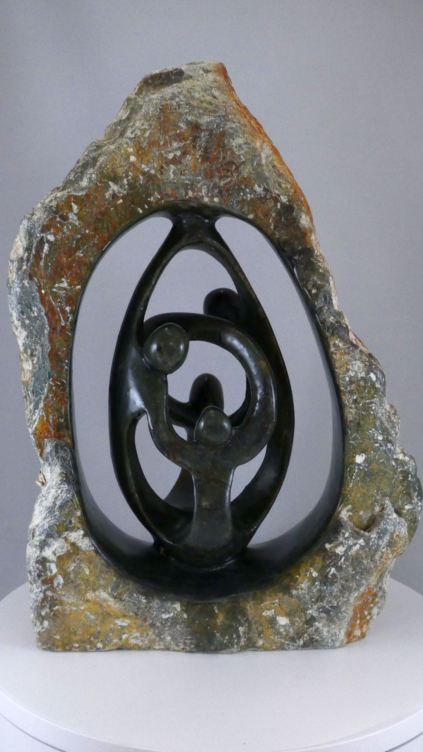 Stenen beeld, 4 personen, 35 cm hoog, buitenzijde ruw, binnenzijde glad afgewerkt