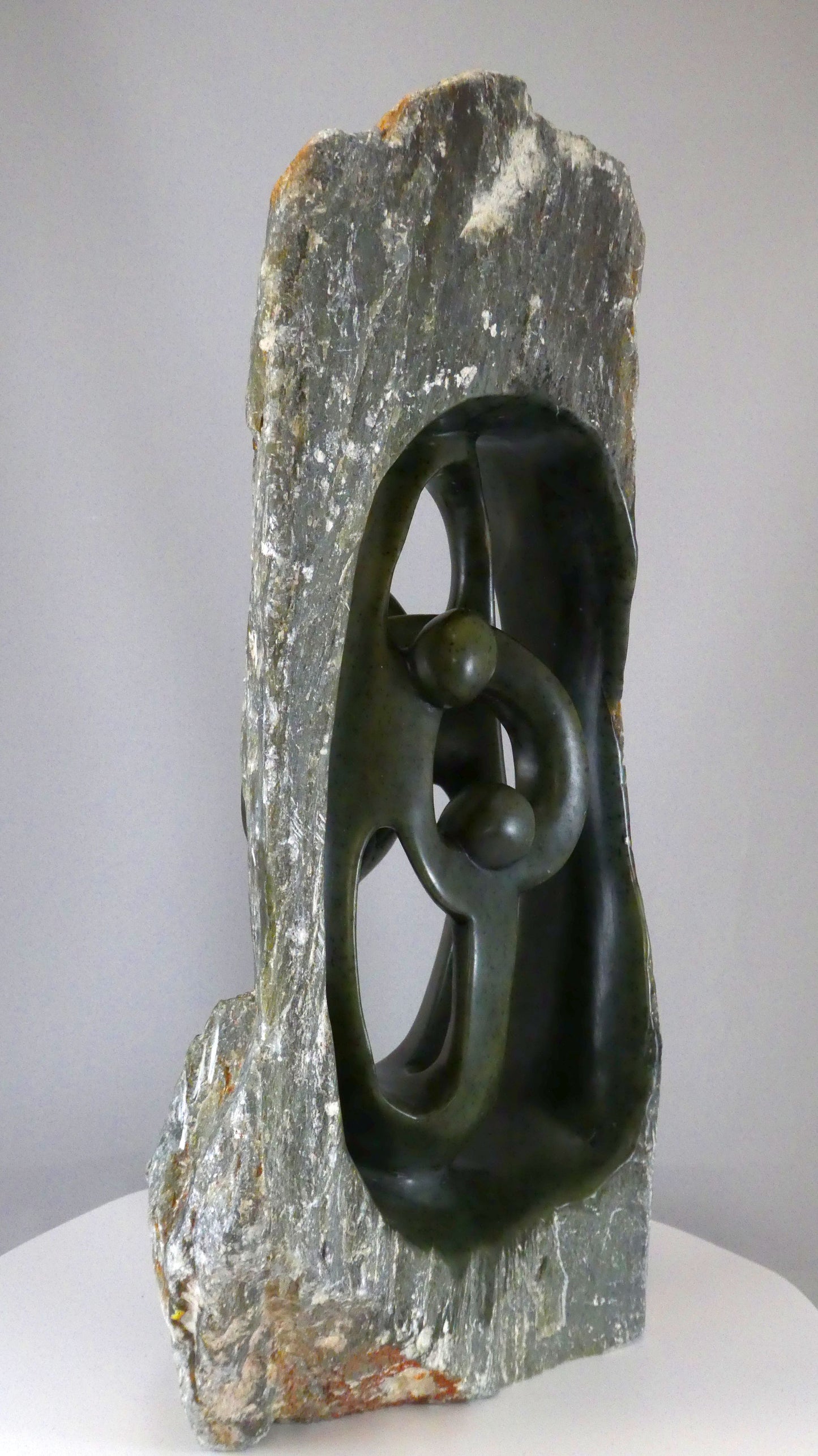 Stenen beeld, 4 personen, 39 cm hoog, buitenzijde ruw, binnenzijde glad afgewerkt