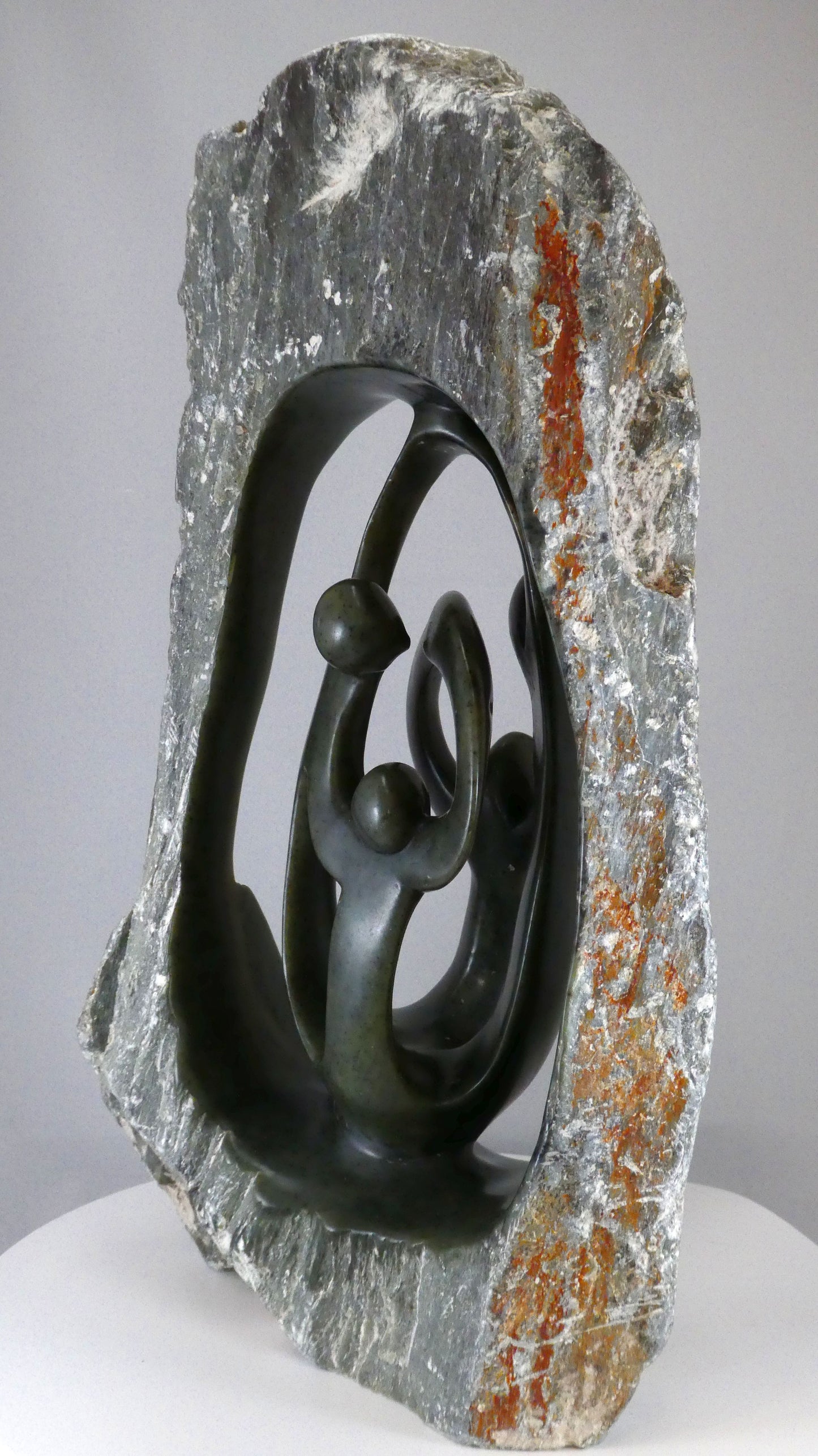 Stenen beeld, 4 personen, 39 cm hoog, buitenzijde ruw, binnenzijde glad afgewerkt