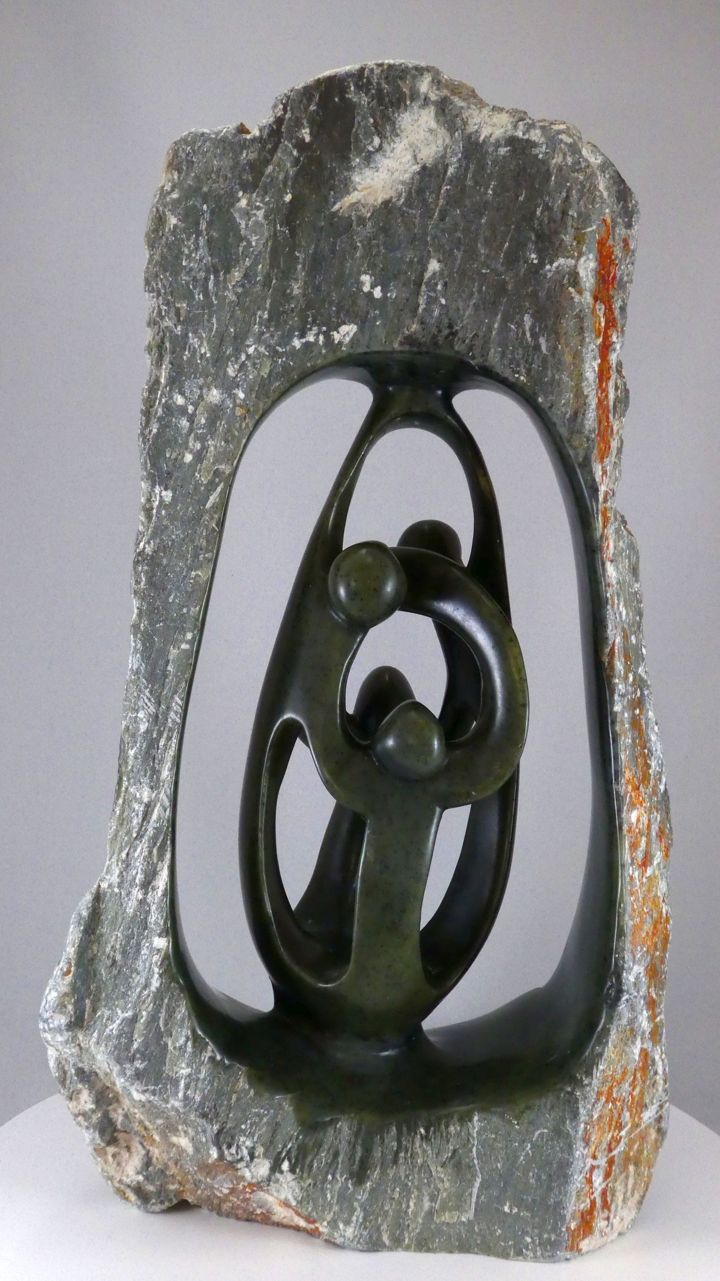 Stenen beeld, 4 personen, 39 cm hoog, buitenzijde ruw, binnenzijde glad afgewerkt