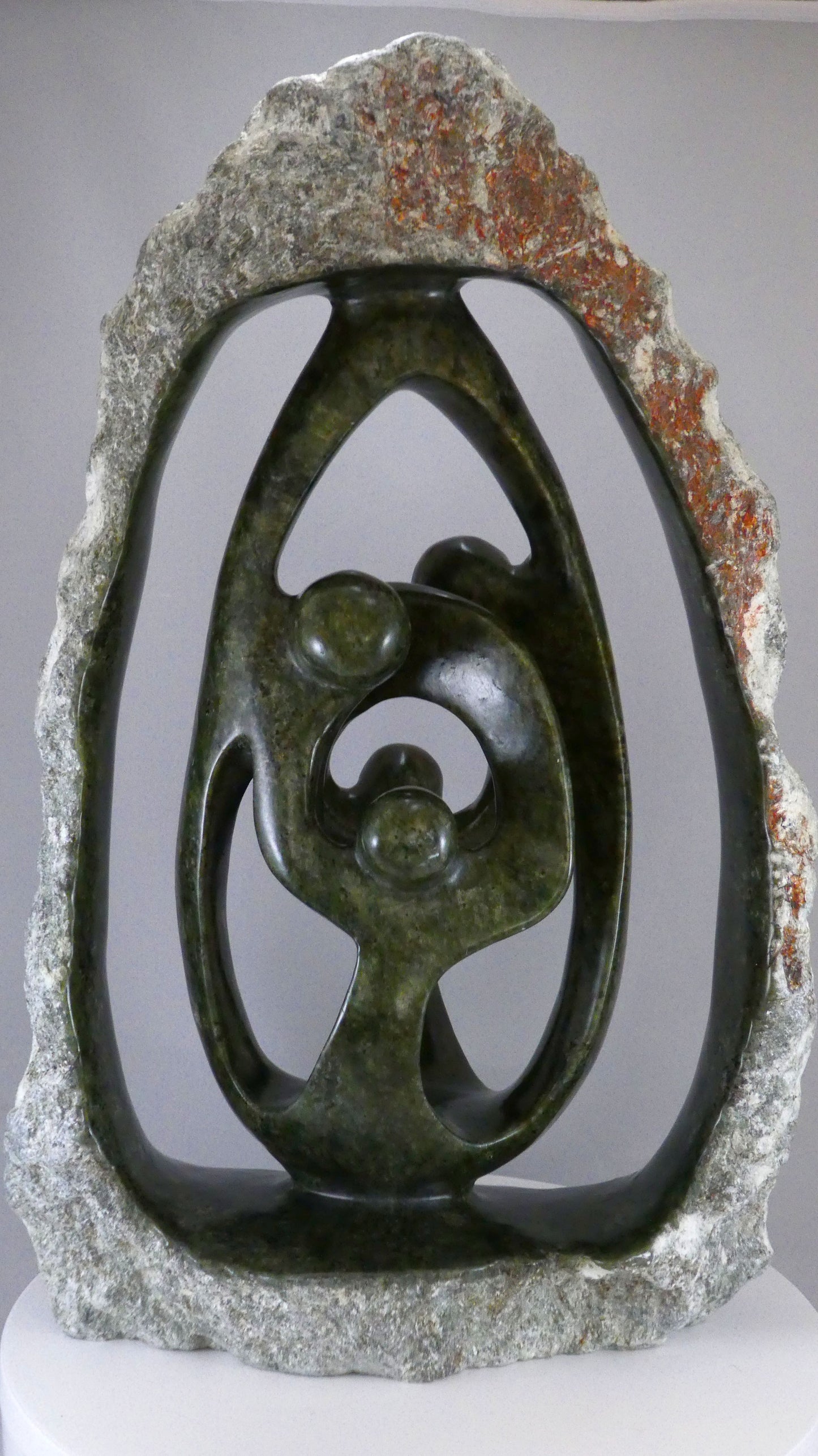 Stenen beeld, 4 personen, 45 cm hoog, buitenzijde ruw, binnenzijde glad afgewerkt