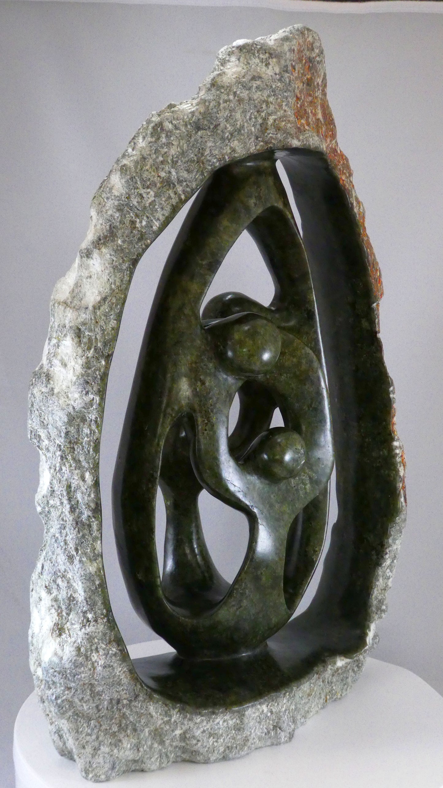 Stenen beeld, 4 personen, 45 cm hoog, buitenzijde ruw, binnenzijde glad afgewerkt