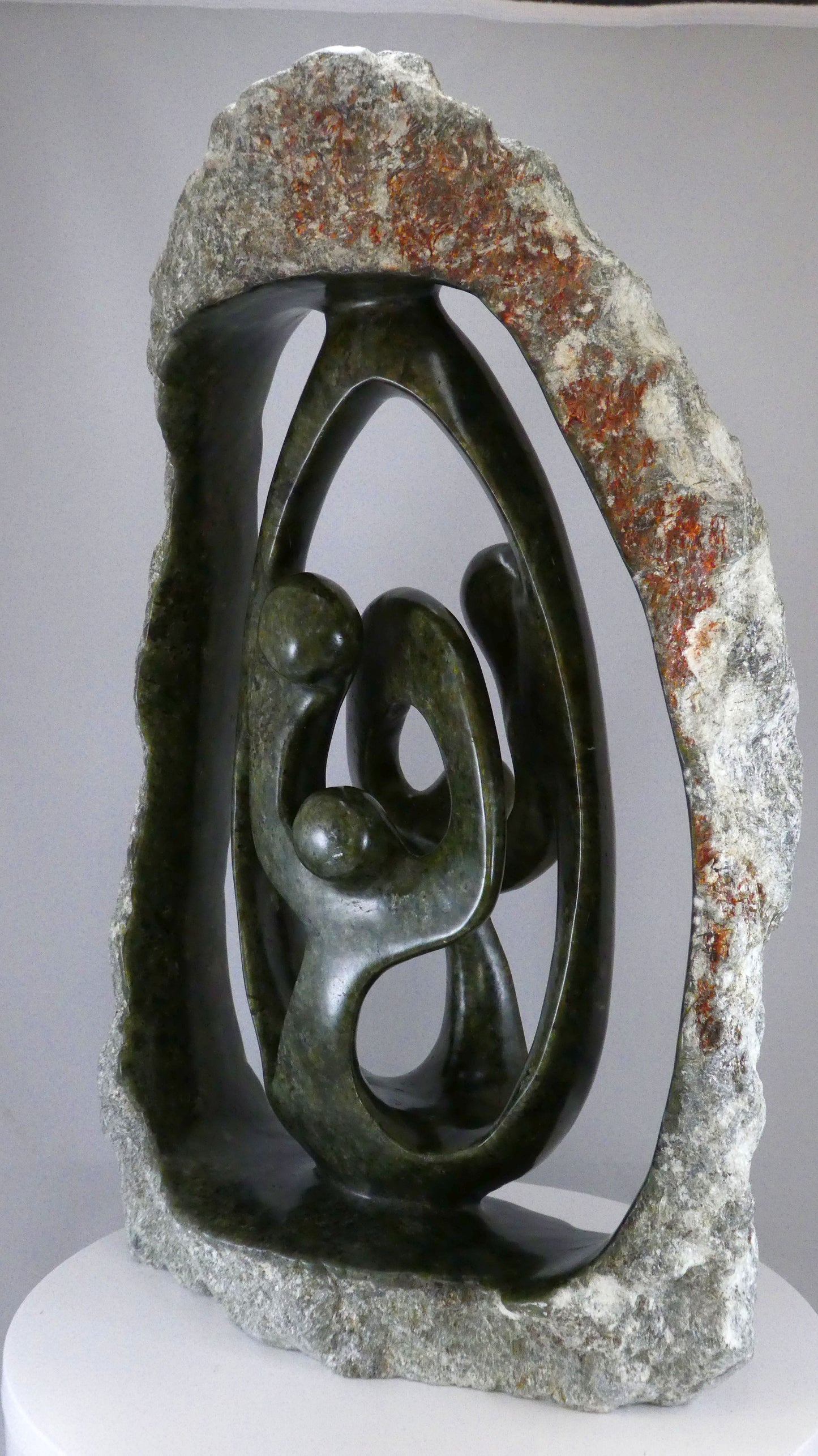 Stenen beeld, 4 personen, 45 cm hoog, buitenzijde ruw, binnenzijde glad afgewerkt